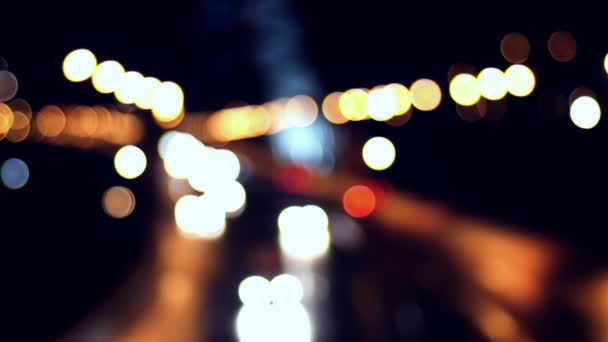 Bokeh-Lichter von Autos, die nachts auf der Stadtstraße fahren — Stockvideo