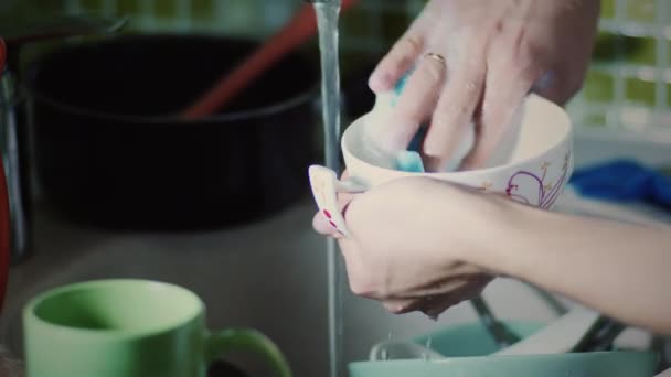 Жінка миє посуд губкою — стокове відео