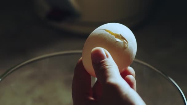 Person breaks chicken egg with a kitchen knife — Stock Video