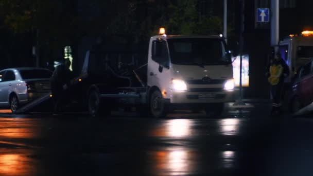 Camiones de remolque y la policía toman coches de la calle por la noche — Vídeos de Stock