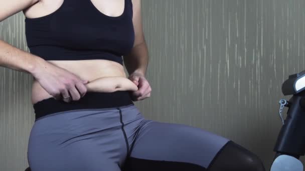 Frau untersucht die Falten am Bauch — Stockvideo