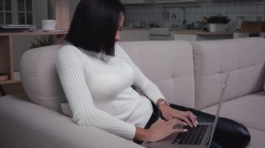 Ev ofisinde çalışan laptoplu bir kadın.