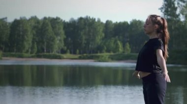 Kız dışarıda nefes egzersizi yapıyor.