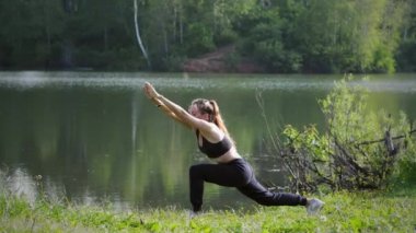 Dışarıda yoga yapan genç bir kadın.