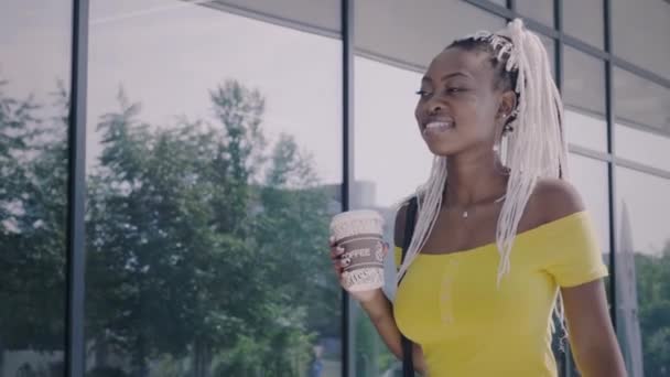 Afrikansk amerikansk kvinna går med kaffe — Stockvideo