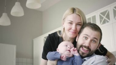 Mutlu aile babası anne ve küçük çocuk gülümsüyor.