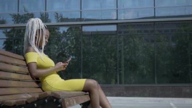 Akıllı telefon kullanan Afrikalı genç bir kadın.