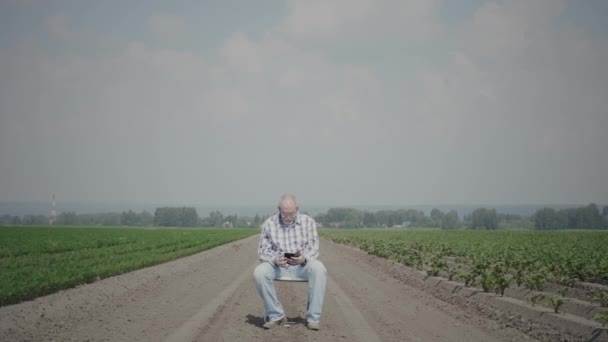 Старшие используют смартфон в полевых условиях — стоковое видео