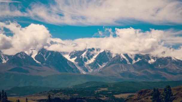 Облака, покрывающие заснеженные вершины высоких гор — стоковое видео