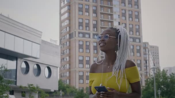 Chica negra usando auriculares al aire libre — Vídeos de Stock