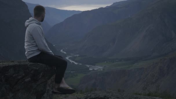 L'homme est assis au sommet de la montagne — Video