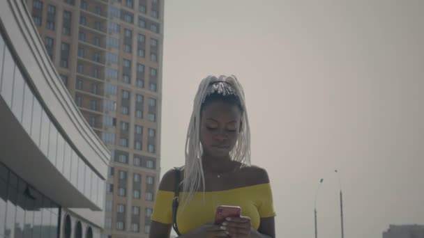 Afroamerikanerin geht mit Handy — Stockvideo