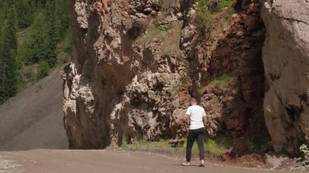 Mann läuft zwischen roten Felsen — Stockvideo