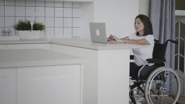 Handicappet kvinde i kørestol fejrer online succes – Stock-video