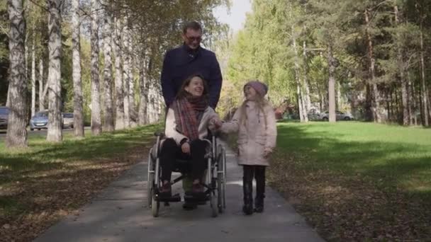 Family with disabled mother, father and daughter walking — Stock Video