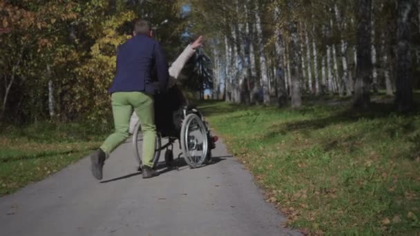 Niepełnosprawna kobieta na wózku inwalidzkim zabawia się z chłopakiem — Wideo stockowe