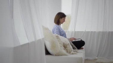 Evdeki bilgisayarını kullanan güzel bir genç kadın.