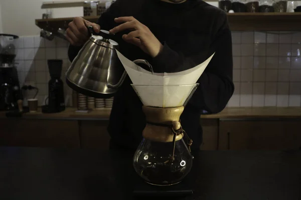 Bir adam Kemeks ve bir su ısıtıcısı elinde kahve brews. Barista bir kafede çalışıyor. Kahve evi. Çocuk barista. bir fantastik kahve yapma adım. chemex