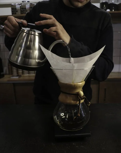 Bir adam Kemeks ve bir su ısıtıcısı elinde kahve brews. Barista bir kafede çalışıyor. Kahve evi. Çocuk barista. bir fantastik kahve yapma adım. chemex
