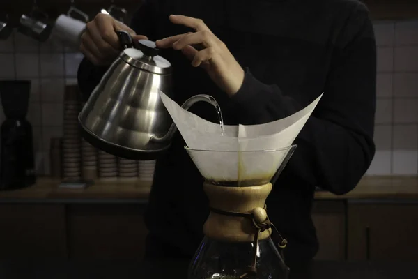 Bir adam Kemeks ve bir su ısıtıcısı elinde kahve brews. Barista bir kafede çalışıyor. Kahve evi. Çocuk barista. bir fantastik kahve yapma adım. chemex