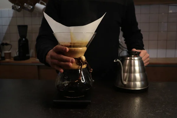 Bir adam Kemeks ve bir su ısıtıcısı elinde kahve brews. Barista bir kafede çalışıyor. Kahve evi. Çocuk barista. bir fantastik kahve yapma adım. chemex