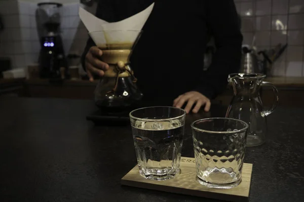 A man brews coffee, in the hands of Kemeks and a kettle. Barista works in a cafe. Coffee house. Boy barista. one of the step of making fantastic coffee. chemex