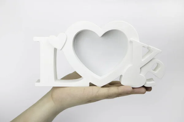 Bir elini bir kitap tutuyor. Bir elini sarı bir defter tutuyor. Beyaz bir arka plan üzerinde. Fotoğraf çerçevesi aşk tutan el