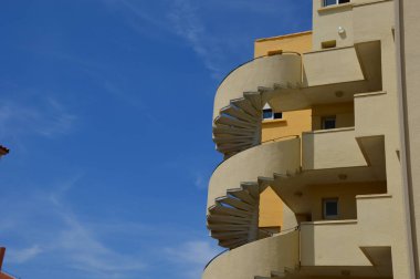 Bir döner merdiven mavi gökyüzü arka plan ile büyütün