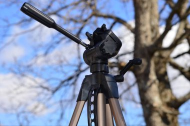 Orman arka plan ile mavi gökyüzünde bir Tripod      