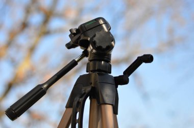 Orman arka plan ile mavi gökyüzünde bir Tripod      
