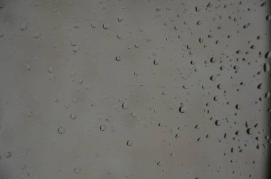 Orman arka planile pencereye yağmur damlaları