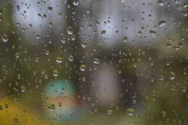 Orman arka planile pencereye yağmur damlaları