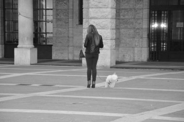 Bir kadın köpeğini boş bir tarih ile İtalya'da kare ve onun smartphone ile ilgilenir