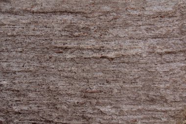 Çatlakları, lekeleri, düzensizlikleri olan taş bir yüzey..