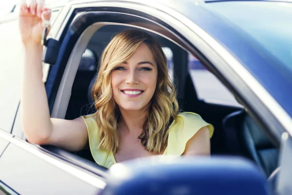 차에 매력적인 여자는 그녀의 손에 차 키를 보유 하고있다. 임대 또는 구입-자동차의 개념. — 스톡 사진