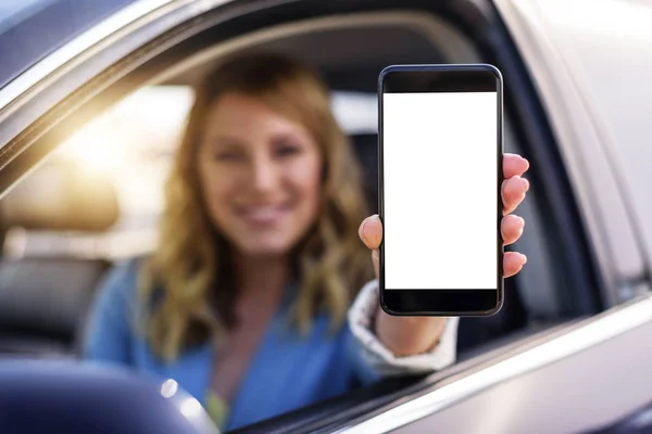 Jovem mulher em auto mostra smartphone com tela em branco . — Fotografia de Stock