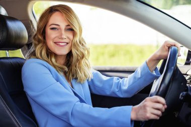 Bir yaz gününde gülümseyen kadın arabada.