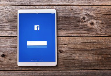 IPad sosyal ağ Facebook üzerinde ahşap bir masa üstünde belgili tanımlık perde ile pro.