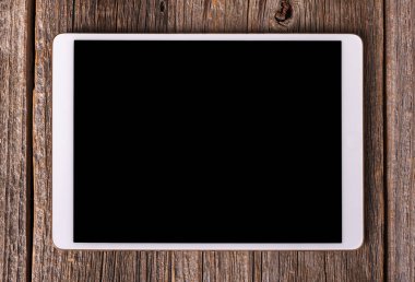 Eski ahşap masa arka plan beyaz tablet PC'de.