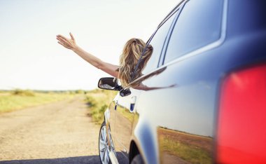 Çekici bir kadın arabada bir araba anahtarı elinde tutar..