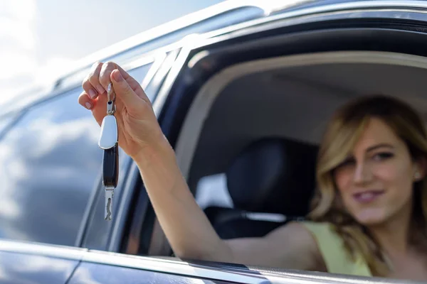 Atraktivní žena v autě dostane klíče od auta. Pronajmout nebo koupit auto. — Stock fotografie