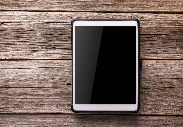 Eski ahşap masa arka plan beyaz tablet PC'de.
