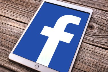 IPad sosyal ağ Facebook üzerinde ahşap bir masa üstünde belgili tanımlık perde ile pro.