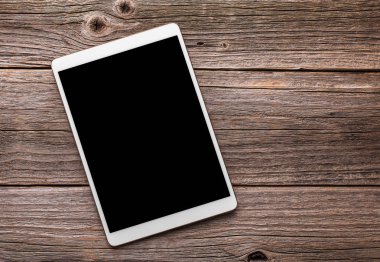 Eski ahşap masa arka plan beyaz tablet PC'de.