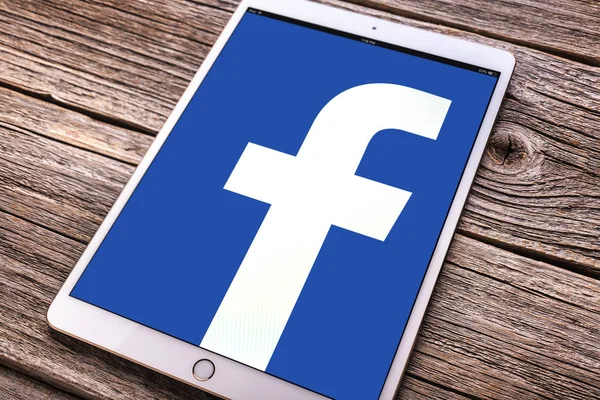 Ipad pro con Facebook red social en la pantalla, en una mesa de madera . —  Fotos de Stock