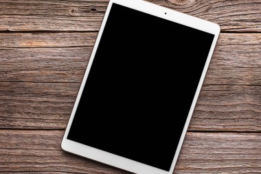 Eski ahşap masa arka plan beyaz tablet PC'de.
