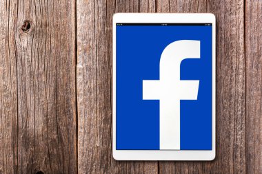 IPad sosyal ağ Facebook üzerinde ahşap bir masa üstünde belgili tanımlık perde ile pro.