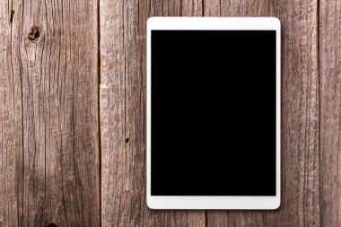 Eski ahşap masa arka plan beyaz tablet PC'de.