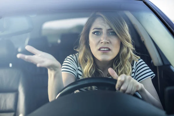 Angry woman driving a car. — Stock Photo, Image