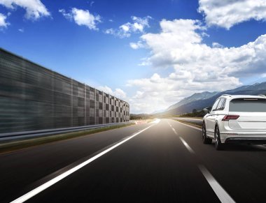 Güneş yüksek hızlı bir yolu boyunca acele bir beyaz araba.